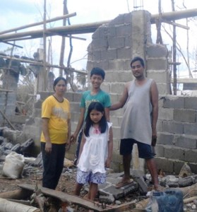 Fernanda family stand outside ruins of home on Panay Island, Nov. 2013.